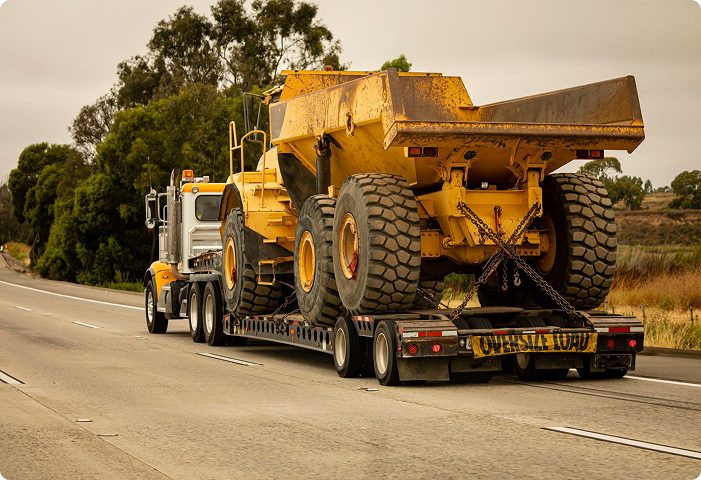 Lowboy and RGN trailer transport for oversized industrial machinery